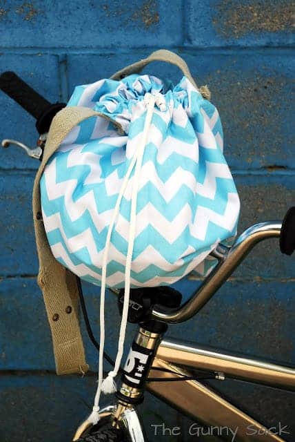 a chevron patterned blue and white tote bag on the handlebars of a bike.