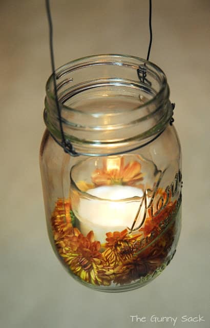 mason jar with lit candle and mums
