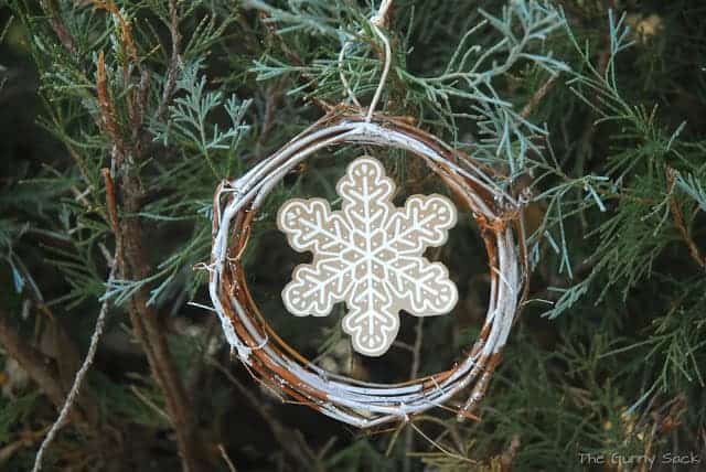 a snowflake ornament hanging in a tree.