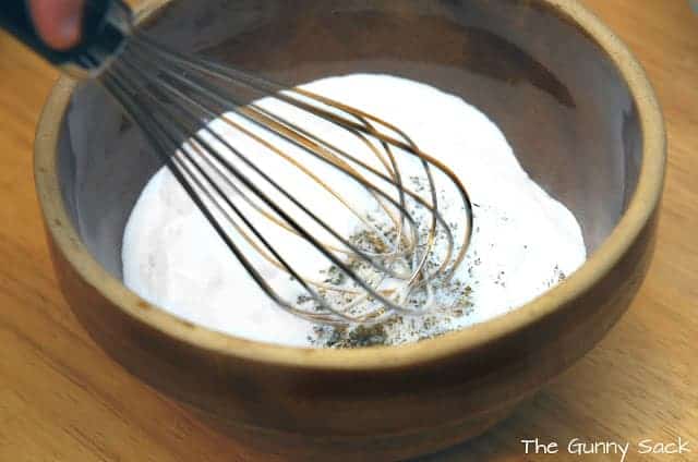 a whisk in a bowl with foot soak ingredients.