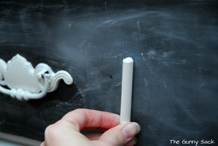 a hand holding a piece of white chalk.