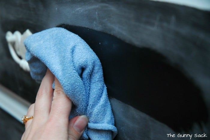  A hand using a rag to wipe off chalk dust.