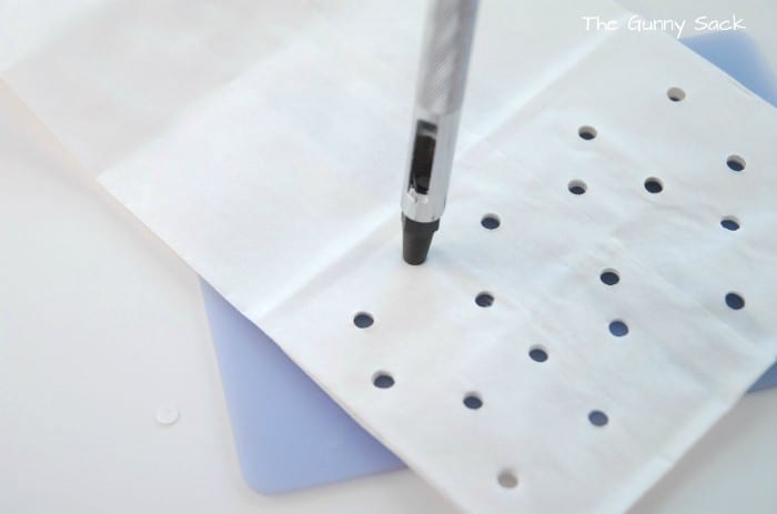 A white paper lunch bag with holes punched in it.