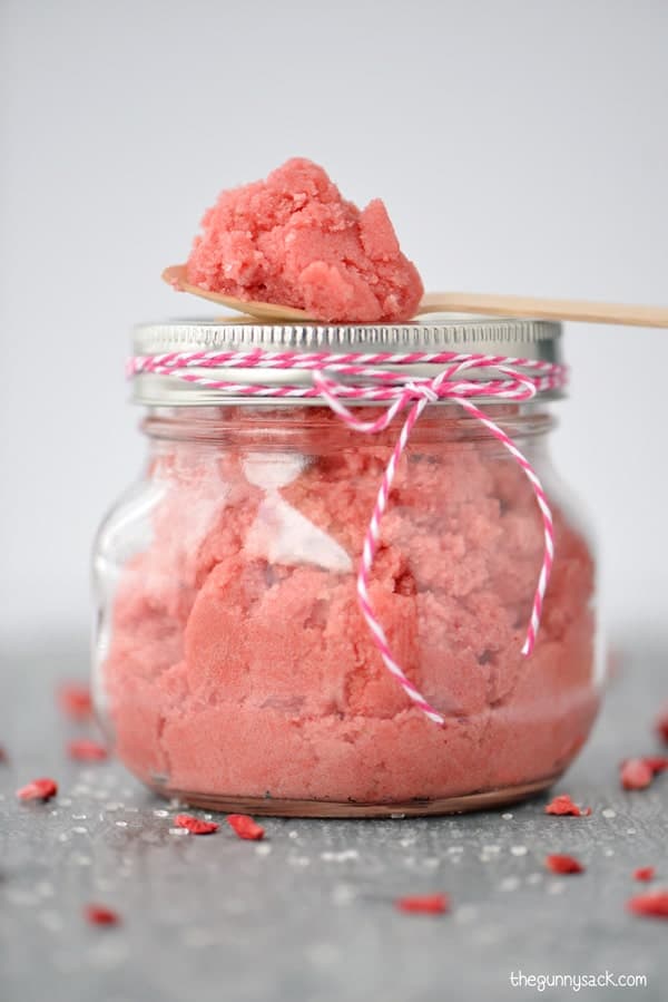 Strawberry Sugar Scrub in a mason jar with a scoop on top