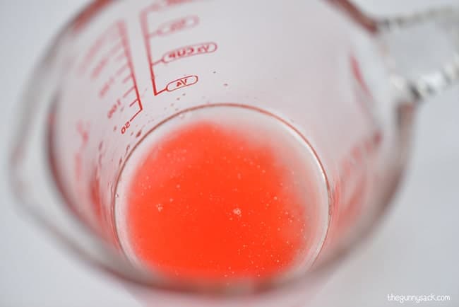 coconut oil and food coloring in a glass measuring cup.