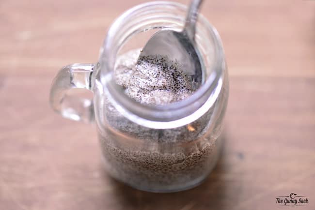 spoon sugar scrub into mason jar