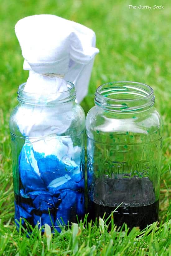 a jar full of clothing dye, with a cloth bag dipped into it.