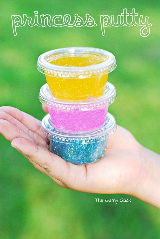 A hand holding small containers of princess putty.