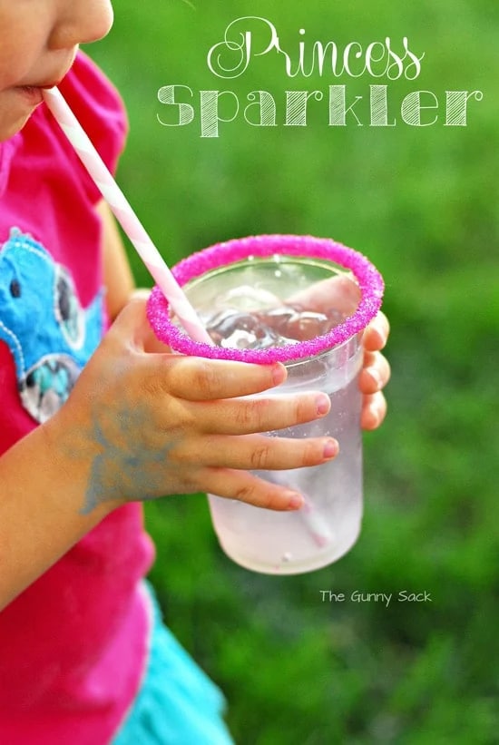 A child drinking from a pink rimmed cup.