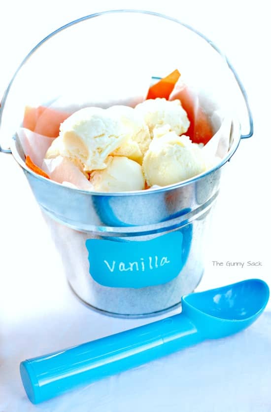 Scoops of vanilla ice cream in a metal pail.
