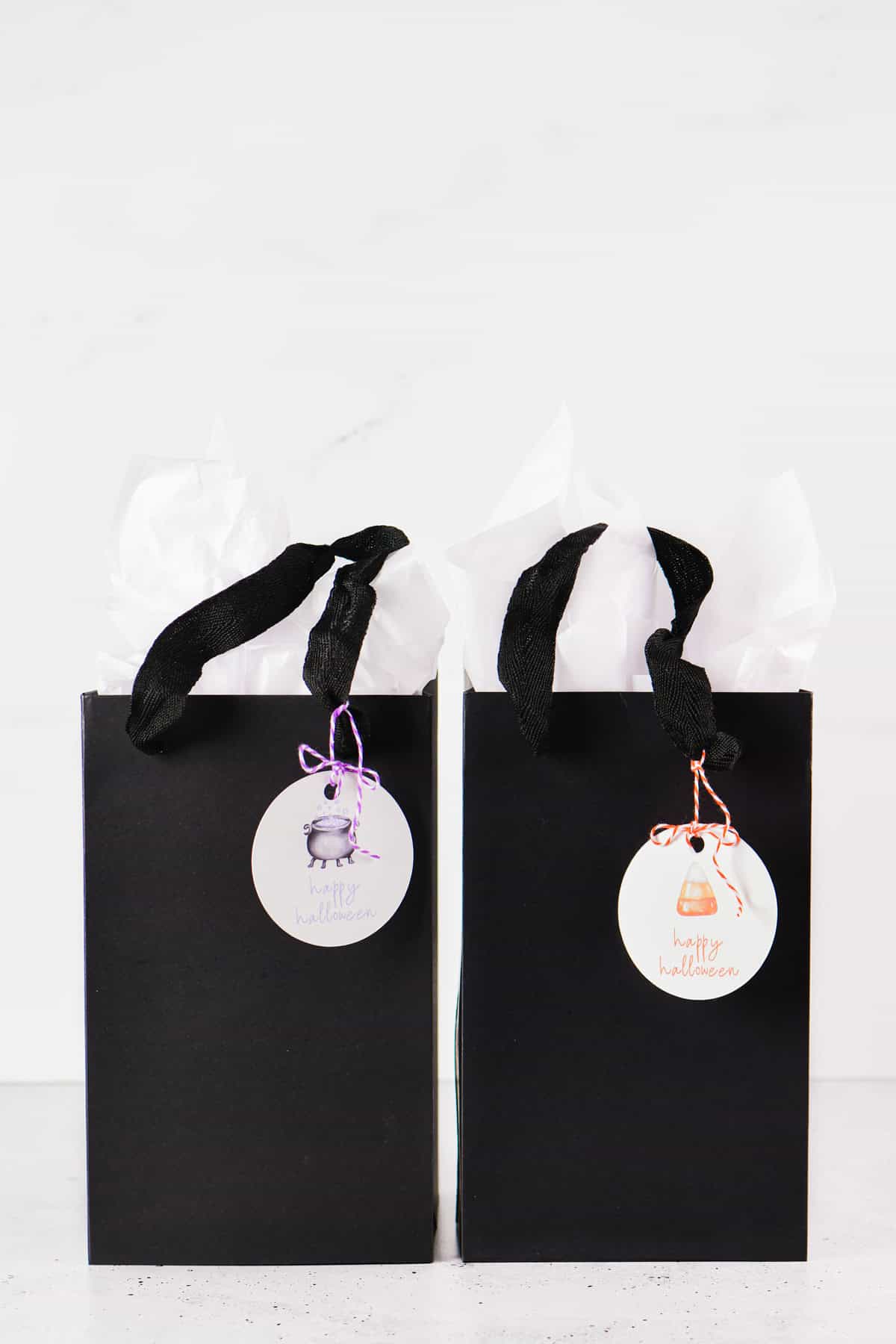 Halloween gift tags tied to black bags with twine.