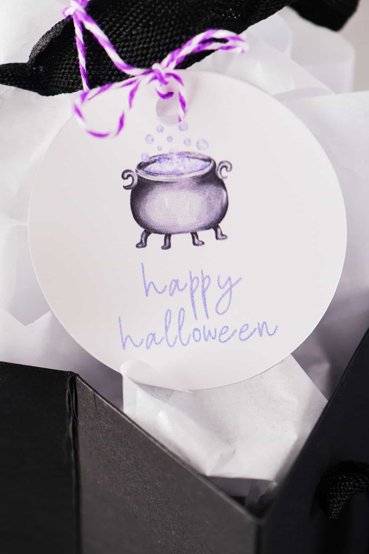 Happy halloween witches brew gift tag on a black bag.