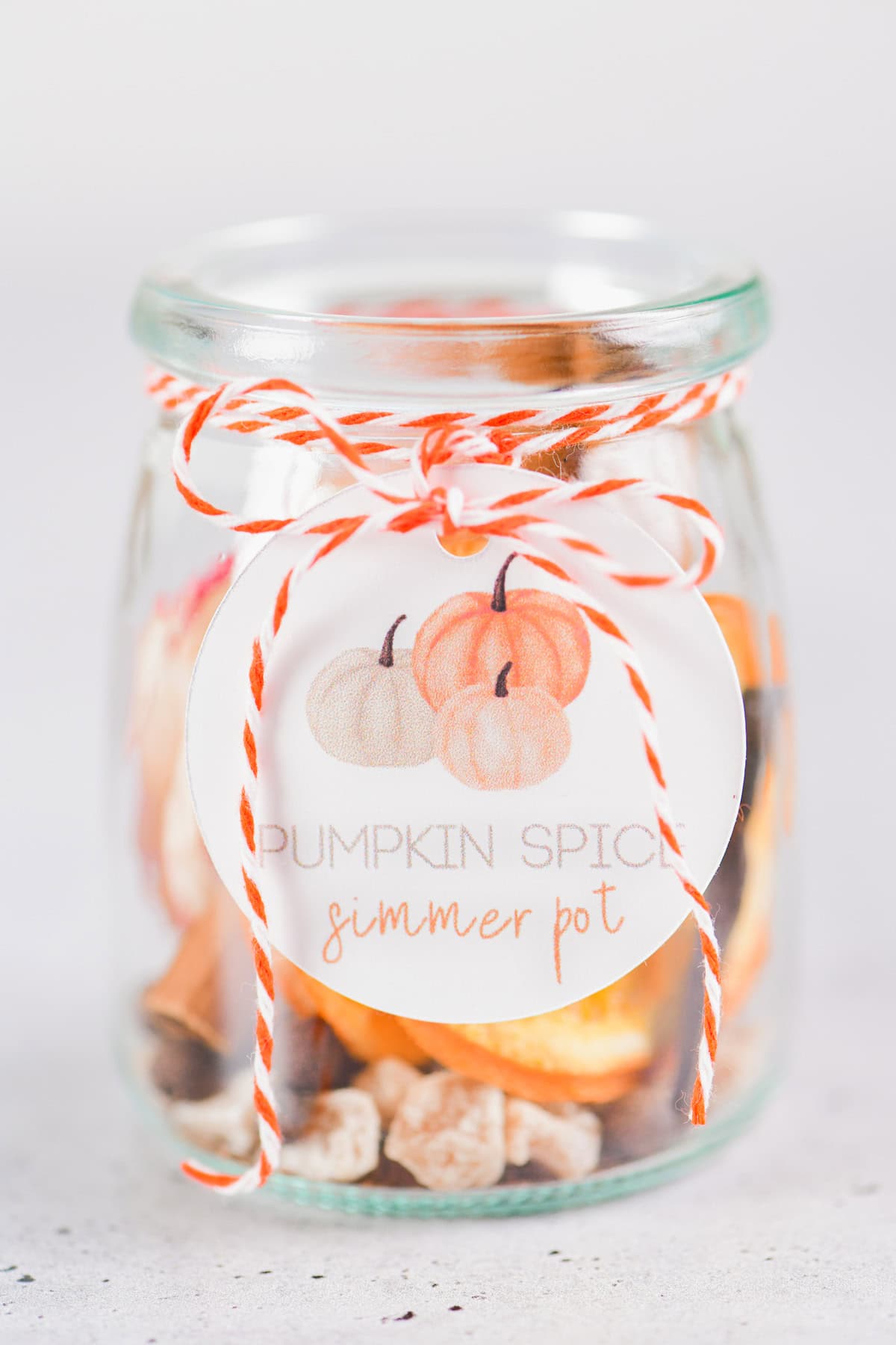 Pumpkin spice simmer pot label attached to the jar with orange and white baker's twine.