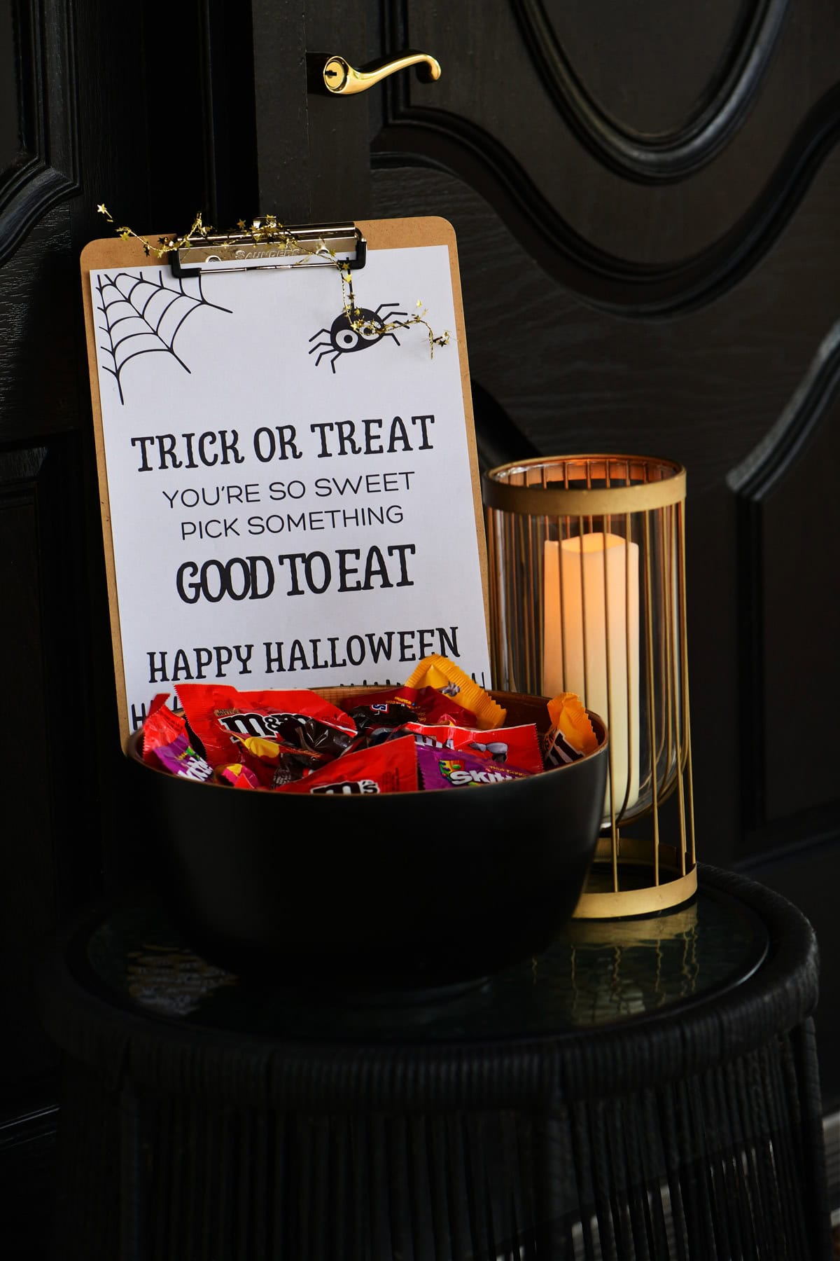 Trick or treat sign printable with candy and a candle.